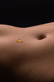 Beautiful female body in honey on a dark background, studio