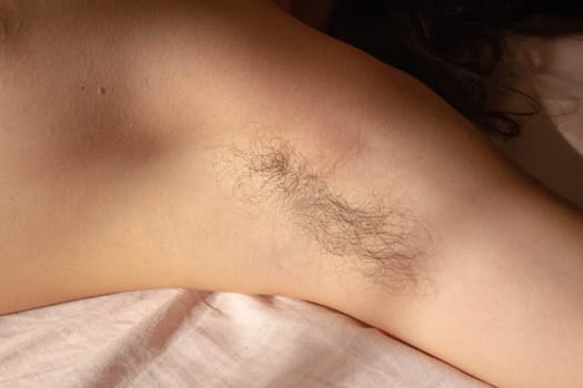 Challenge beauty standards and celebrate natural authenticity with this empowering image of a female armpit adorned with hair