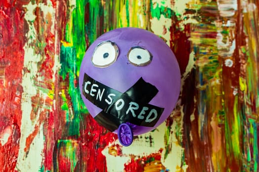 In a vivid juxtaposition of color and constraint, behold this symbolic image featuring a balloon with its mouth taped shut, suspended against a backdrop of vibrant, colorful painting