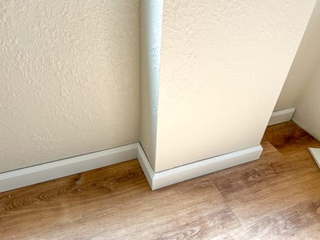 Witness the professional installation of vinyl baseboards in a stylish modern home, adding a sleek finishing touch to the interior design.