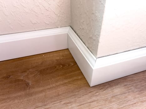 Witness the professional installation of vinyl baseboards in a stylish modern home, adding a sleek finishing touch to the interior design.