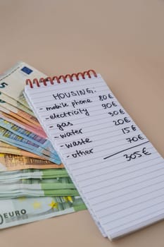 Counting expenses bills on housing electricity, gas, water. Banknotes of euro cash around. High prices for energy inflation crisis. Cut back on spending. Savings rate