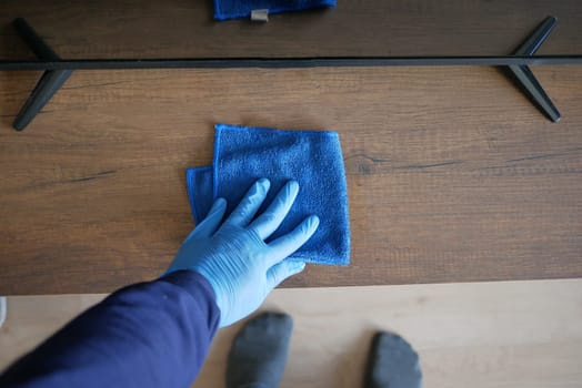 hand holding spray bottle and cleaning table .