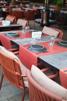 A city restaurant with orange and black outdoor furniture,