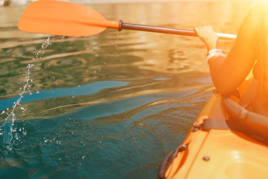 Kayak paddle sea vacation. Person paddles with orange paddle oar on kayak in sea. Leisure active lifestyle recreation activity rest tourism travel.