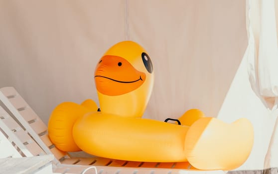 Inflatable duckling, pool, summer - Bright yellow floatation device enhances swimming experience for children during warm days.