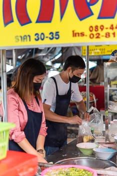 Bangkok, Thailand - November 27, 2022 : Unidentified Asian chef cooking a noodle soup with meat ball (kauy-tiew) for sale at Thai street food market or restaurant in Thailand