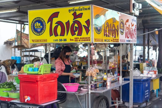 Bangkok, Thailand - November 27, 2022 : Unidentified Asian chef cooking a noodle soup with meat ball (kauy-tiew) for sale at Thai street food market or restaurant in Thailand