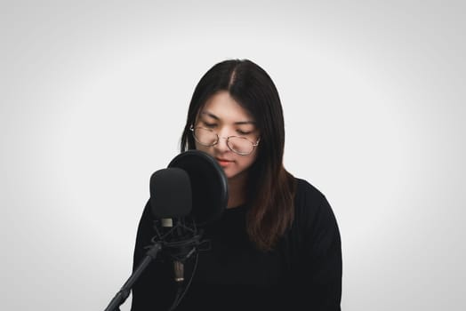 Beautiful asian woman (LGBTQ) is a singer. She enjoying sing a song or karaoke in music studio with microphone condenser and headphones for fun or voice creative