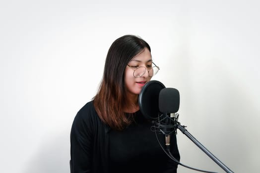 Beautiful asian woman (LGBTQ) is a singer. She enjoying sing a song or karaoke in music studio with microphone condenser and headphones for fun or voice creative