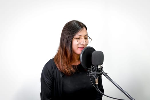 Beautiful asian woman (LGBTQ) is a singer. She enjoying sing a song or karaoke in music studio with microphone condenser and headphones for fun or voice creative