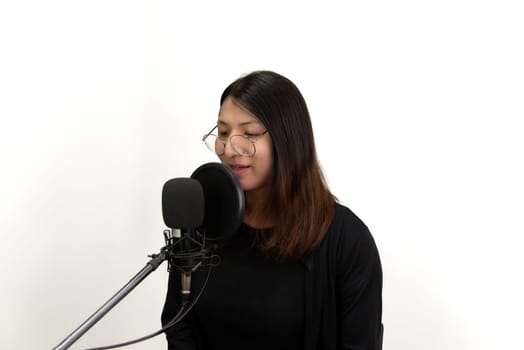 Beautiful asian woman (LGBTQ) is a singer. She enjoying sing a song or karaoke in music studio with microphone condenser and headphones for fun or voice creative