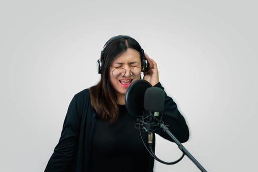 Beautiful asian woman (LGBTQ) is a singer. She enjoying sing a song or karaoke in music studio with microphone condenser and headphones for fun or voice creative