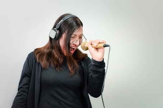 Beautiful asian woman (LGBTQ) is a singer. She enjoying sing a song or karaoke in music studio with microphone condenser and headphones for fun or voice creative