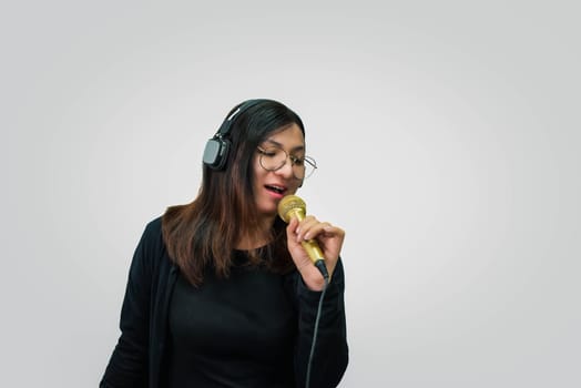 Beautiful asian woman (LGBTQ) is a singer. She enjoying sing a song or karaoke in music studio with microphone condenser and headphones for fun or voice creative