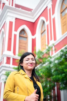 Beautiful asian woman (LGBTQ) natural makeup wear fashion yellow leather clothes with glasses posing at old town and vintage building outdoor fashion style