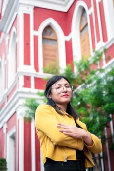 Beautiful asian woman (LGBTQ) natural makeup wear fashion yellow leather clothes with glasses posing at old town and vintage building outdoor fashion style