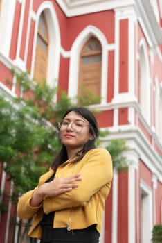 Beautiful asian woman (LGBTQ) natural makeup wear fashion yellow leather clothes with glasses posing at old town and vintage building outdoor fashion style