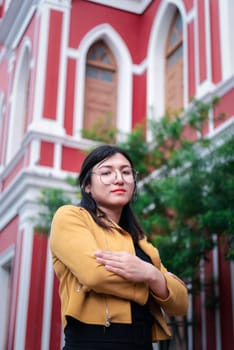 Beautiful asian woman (LGBTQ) natural makeup wear fashion yellow leather clothes with glasses posing at old town and vintage building outdoor fashion style