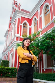 Beautiful asian woman (LGBTQ) natural makeup wear fashion yellow leather clothes with glasses posing at old town and vintage building outdoor fashion style
