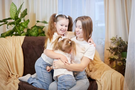 Happy family young mother babysitter relax having fun with cute little children daughters in living room at home