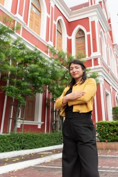 Beautiful asian woman (LGBTQ) natural makeup wear fashion yellow leather clothes with glasses posing at old town and vintage building outdoor fashion style