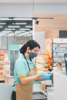 Asian woman work as a barista pouring latte froth to make a coffee latte art into the white coffee cup for serve to customers in the coffee shop cafe