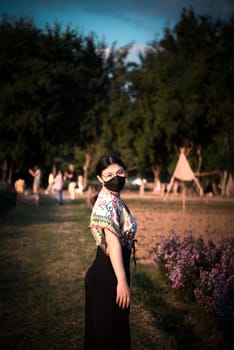 Beautiful asian woman (LGBTQ) natural makeup wear fashion relax clothes posing at nature of flower park or flower garden field lush growing for travel popular landmark in asia outdoor fashion style