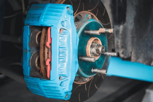 Car mechanic or serviceman disassembly and checking a disc brake and asbestos brake pads for fix and repair problem at car garage or repair shop