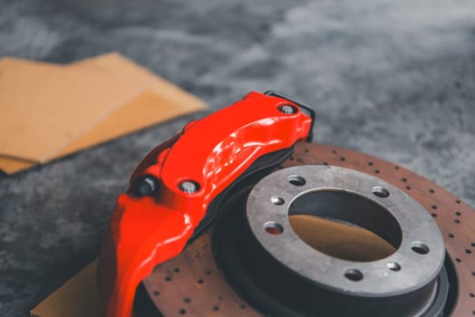 Car mechanic or serviceman disassembly and checking a disc brake and asbestos brake pads for fix and repair problem at car garage or repair shop