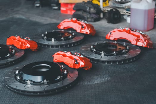 Car mechanic or serviceman disassembly and checking a disc brake and asbestos brake pads for fix and repair problem at car garage or repair shop