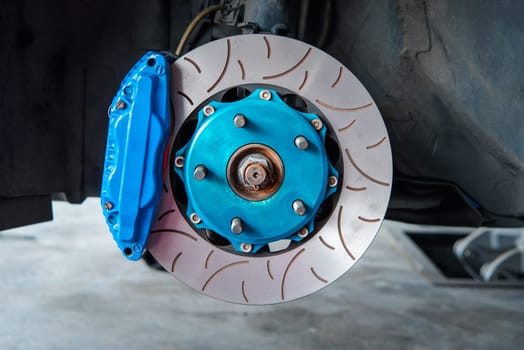 Car mechanic or serviceman disassembly and checking a disc brake and asbestos brake pads for fix and repair problem at car garage or repair shop