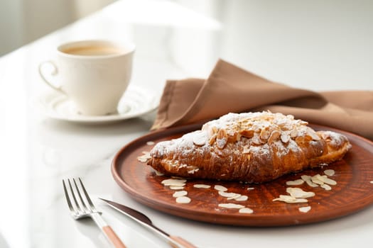 Almond Croissant on clay plate close up photo