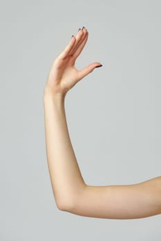 Young woman hand gesture on gray background close up