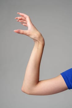 Female hand sign against gray background in studio close up