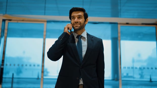 Project manager phone calling to colleague while standing in front of door with blue filter. Smart business man talking or discussing about marketing plan with business team by using phone. Exultant.