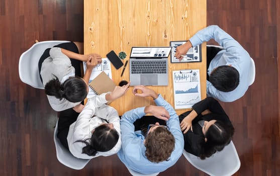 Panorama top view diverse group of business analyst team analyzing financial data report paper on meeting table. Chart and graph dashboard by business intelligence analysis. Meticulous