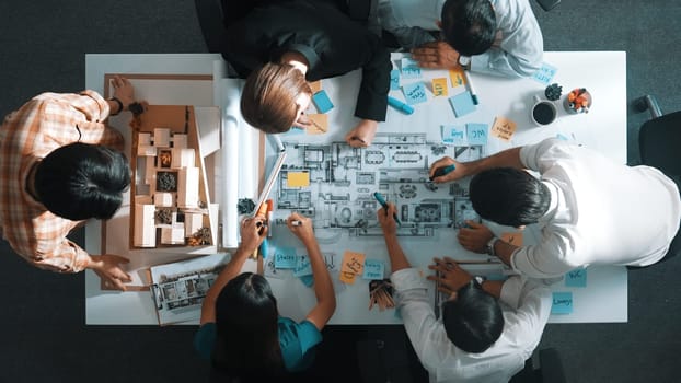 Top aerial view of project manager or civil engineer writing at blueprint and planning building design. Aerial view of architect working together at meeting table with document placed. Alimentation.