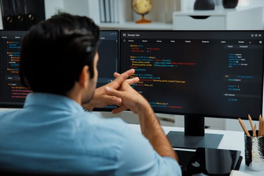 Concentrating in smart IT developer working software development coding on two pc screen, creating virus firmware application program for latest update version on website at modern office. Surmise.