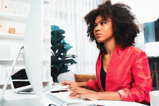 Working African woman blogger concentrated on the laptop screen with serious face, searching marketing data analysis, conclusion overall document on database for meeting report. Tastemaker.