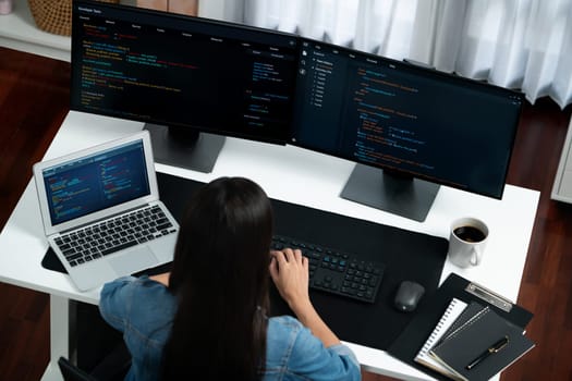 Top view young Asian IT developer creating with typing online information on pc with coding program data of website application, wearing jeans shirt. surround by safety analysis two screen. Stratagem.