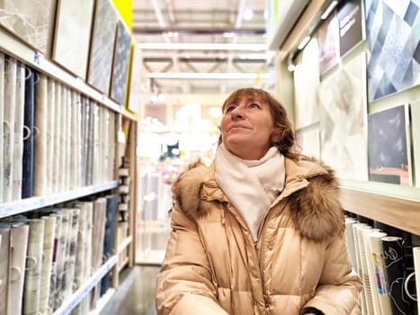 Middle-Aged Woman Shopping at a Warehouse Store. Woman browsing in large retail store aisle