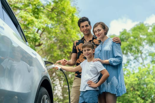 Family road trip vacation with electric vehicle, lovely family recharge EV car with green and clean energy. Natural and eco friendly car travel for sustainable environment. Perpetual