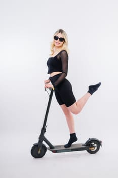 Full length profile shot of female on an electric scooter isolated on white and red background