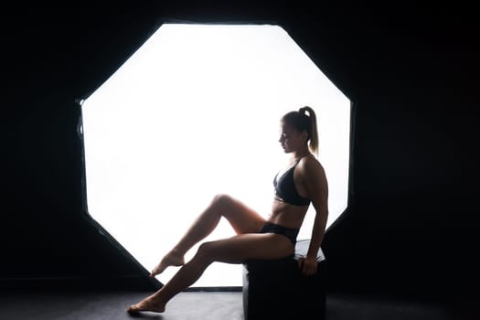 Silhouette of beautiful young woman wearing underwear in backlight