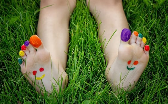 a smile drawn with paints on a child's legs.