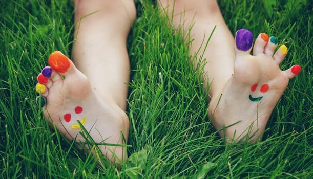 a smile drawn with paints on a child's legs.