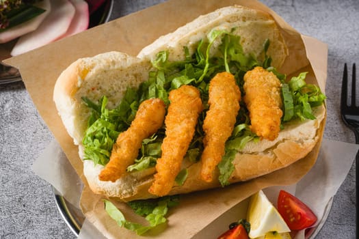 Deep fried shrimp in bread with greens on the side. Shrimp sandwich