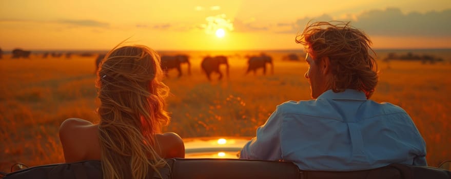 A couple sits in their car, mesmerized by the elephants against the sunset sky. The natural landscape is filled with heat as dusk settles in
