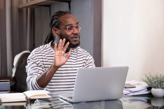 Young African American businessman spends his weekend working from home using his laptop in the living room..